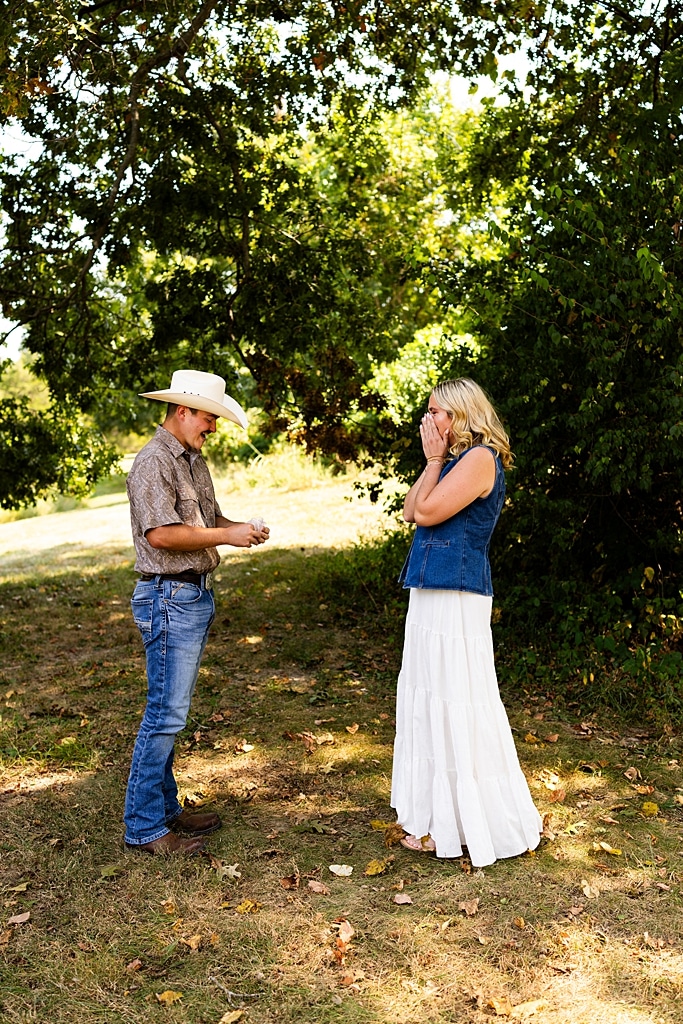 Tyler proposing to Rachel at Chandler Hill Vineyards in Defiance Missouri
Couple standing back to back moments before the surprise proposal
Rachel crying with joy as Tyler kneels during the proposal
Newly engaged couple hugging surrounded by vineyard scenery
Close up of engagement ring in front of rolling vineyard hills